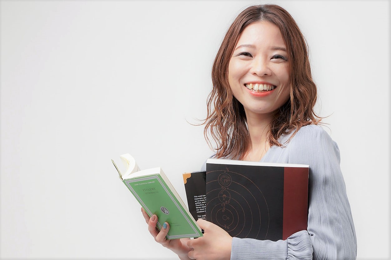 複数の難しそうな書籍を持つ女性